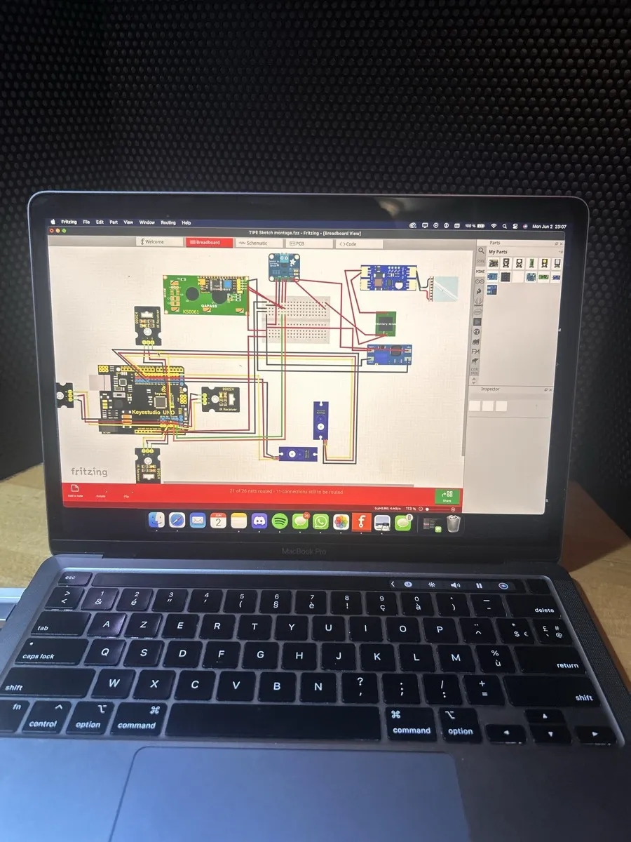 A laptop showing the tracker’s wiring diagram in Fritzing: the Arduino board, two servo motors, sensors and a display connected by colored wires.